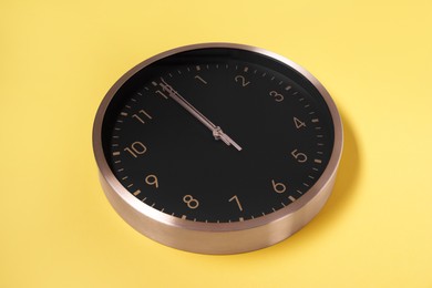 Stylish round clock on yellow background. Interior element