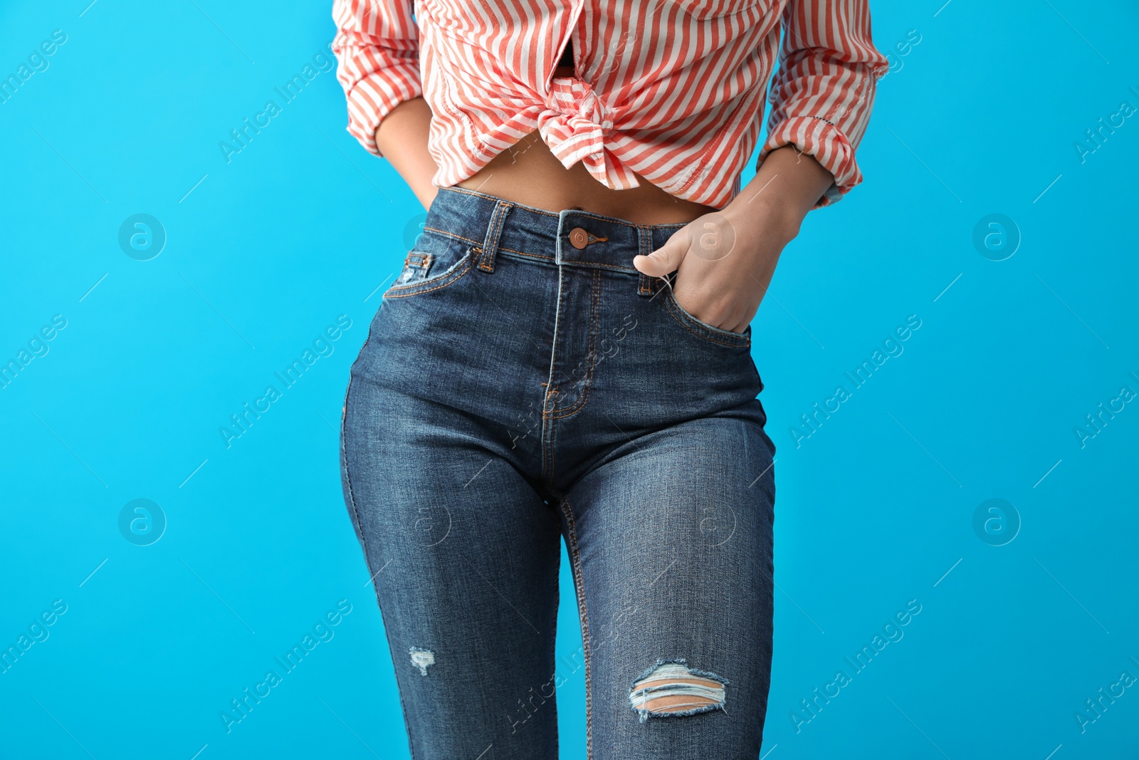 Photo of Woman wearing jeans on blue background, closeup