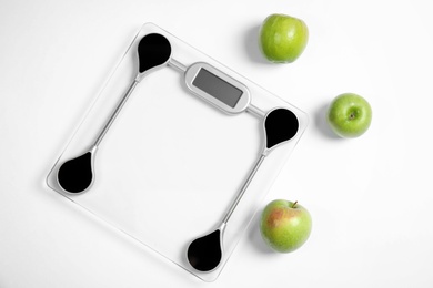 Photo of Modern scales and apples on white background, top view