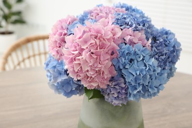 Vase with beautiful hydrangea flowers on table indoors, closeup