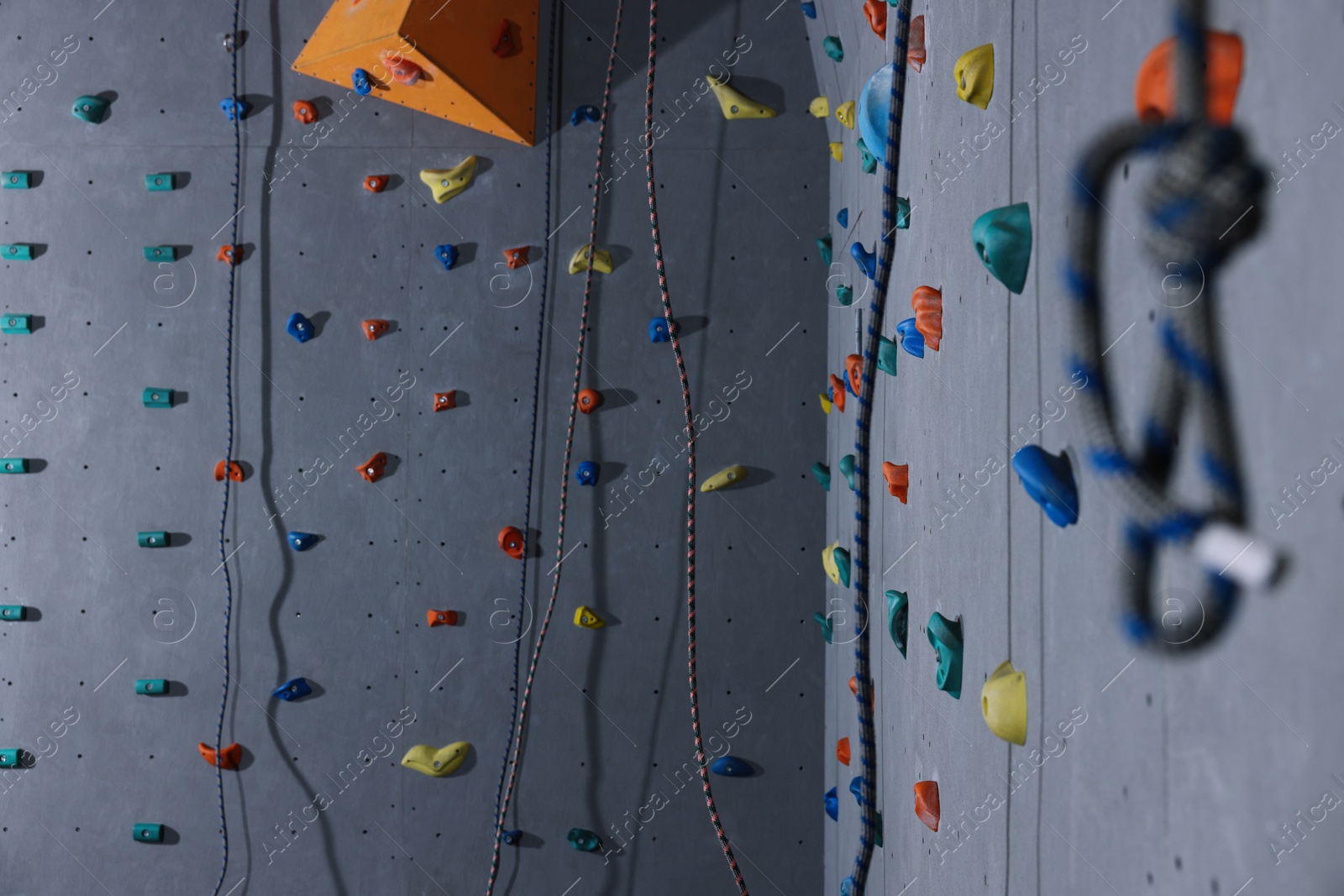 Photo of Wall with holds and climbing ropes in gym