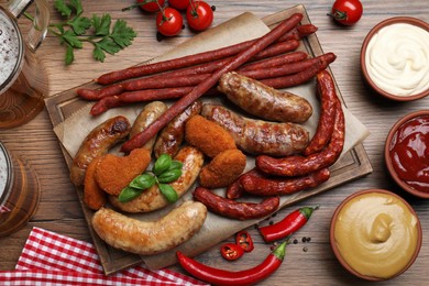 Set of different tasty snacks and beer on wooden table, flat lay