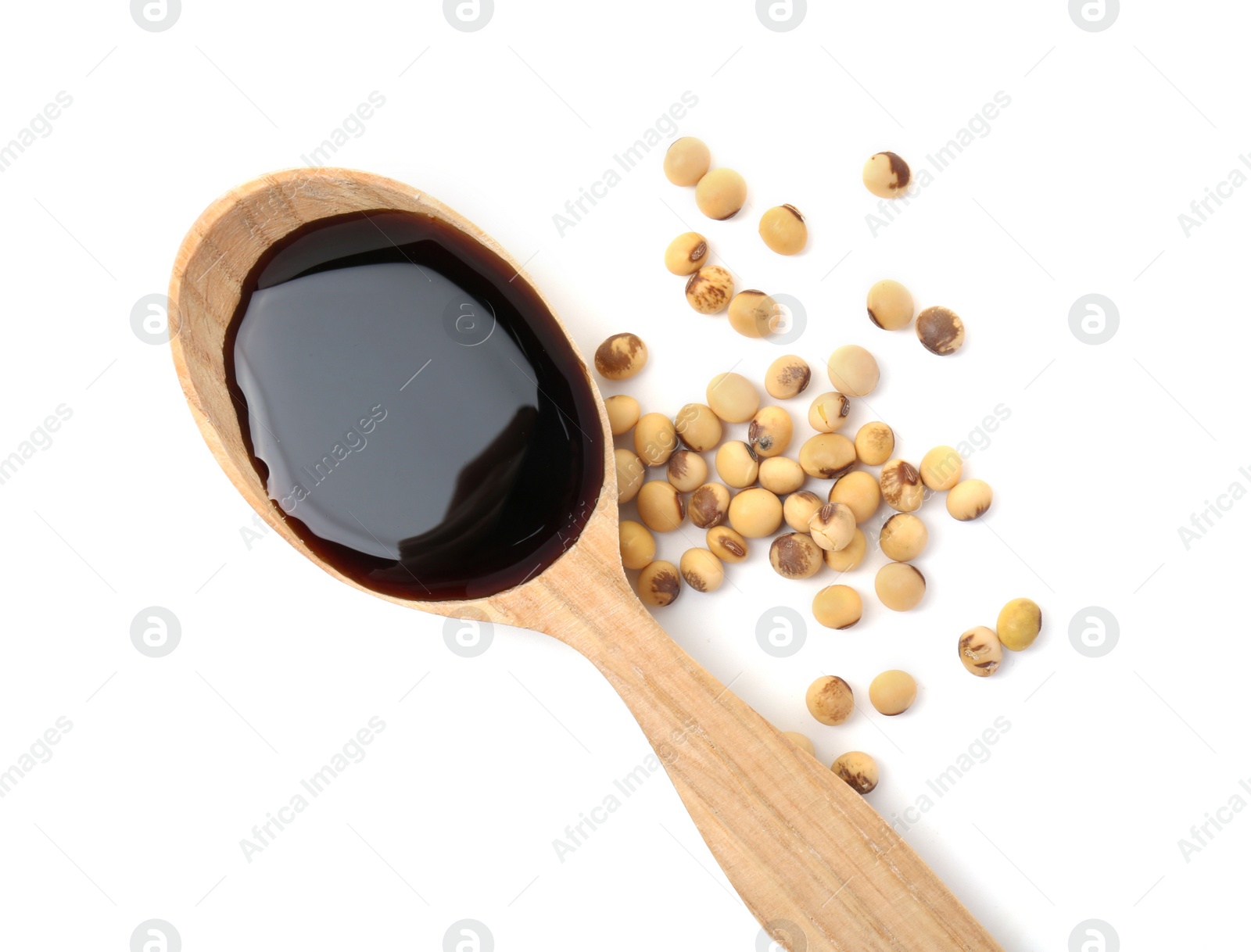 Photo of Tasty soy sauce in spoon and soybeans isolated on white, top view