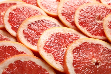 Photo of Many sliced fresh ripe grapefruits as background, closeup