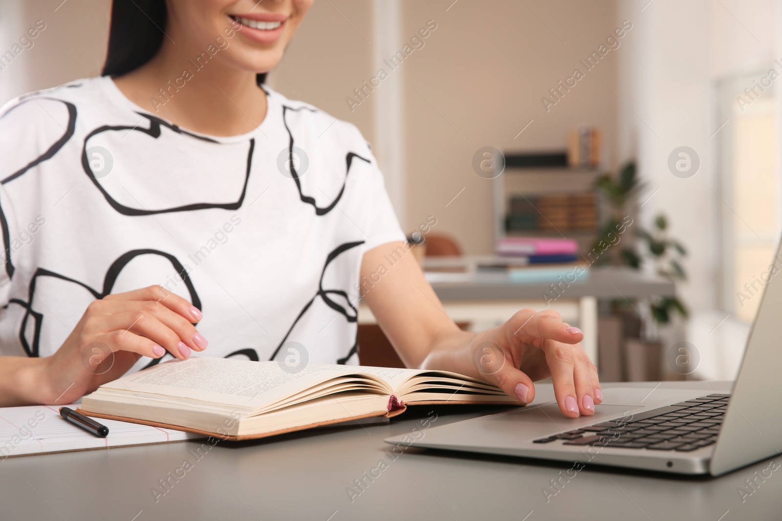 Photo of Young woman studying at table in library, closeup