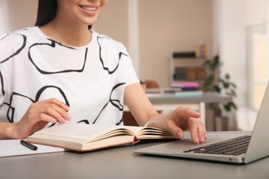 Photo of Young woman studying at table in library, closeup