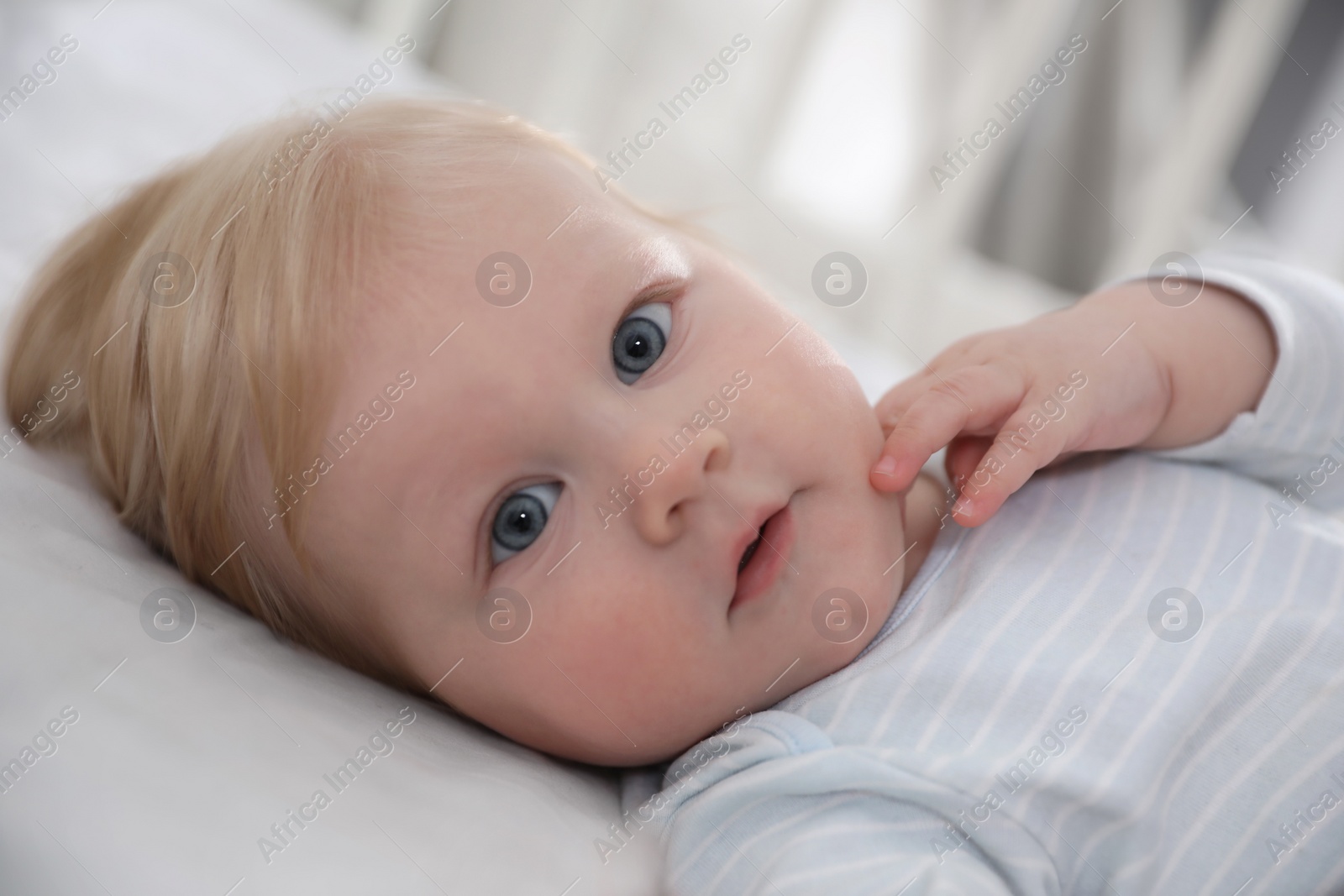 Photo of Cute little baby lying in crib, closeup. Bedtime