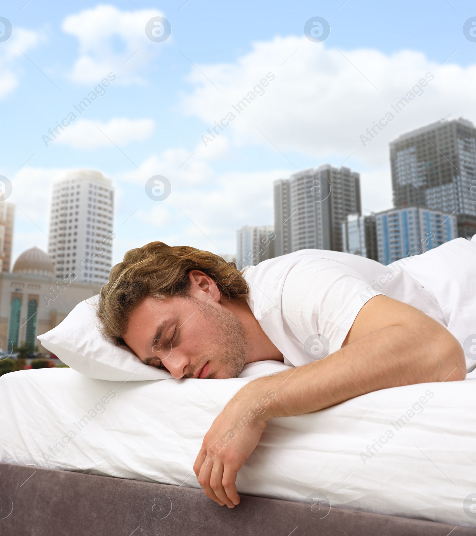 Image of Man sleeping in bed and beautiful view of cityscape on background. Good sleep despite of urban bustle