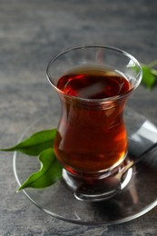 Photo of Glass with traditional Turkish tea on grey table