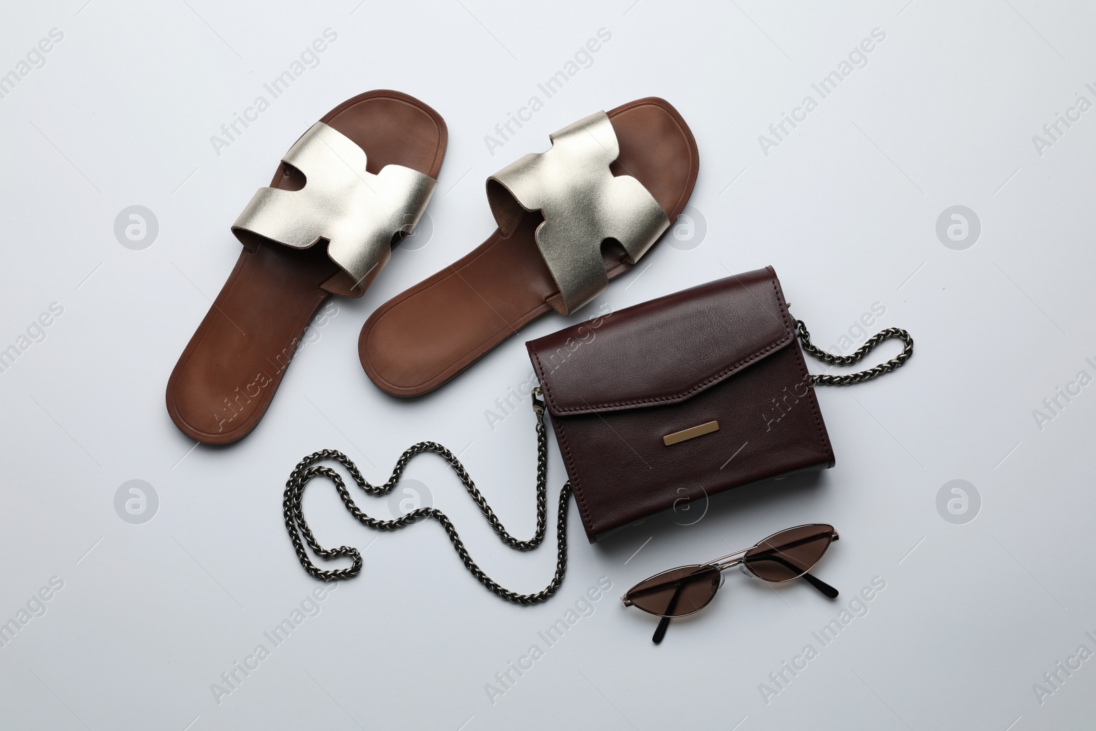 Photo of Stylish woman's bag, sunglasses and shoes on light background, flat lay