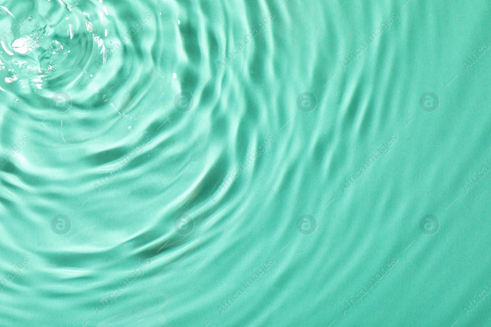 Photo of Closeup view of water with rippled surface on light blue background