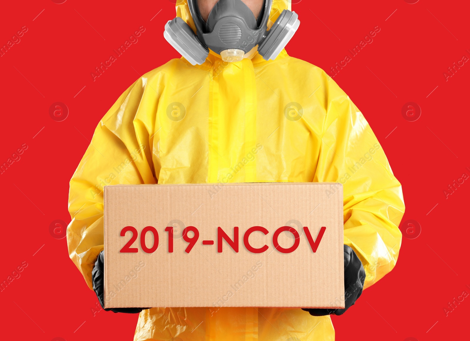 Image of Man wearing chemical protective suit with cardboard box on red background, closeup. Coronavirus outbreak