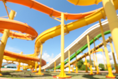 Photo of Colorful slides in water park, blurred bottom view