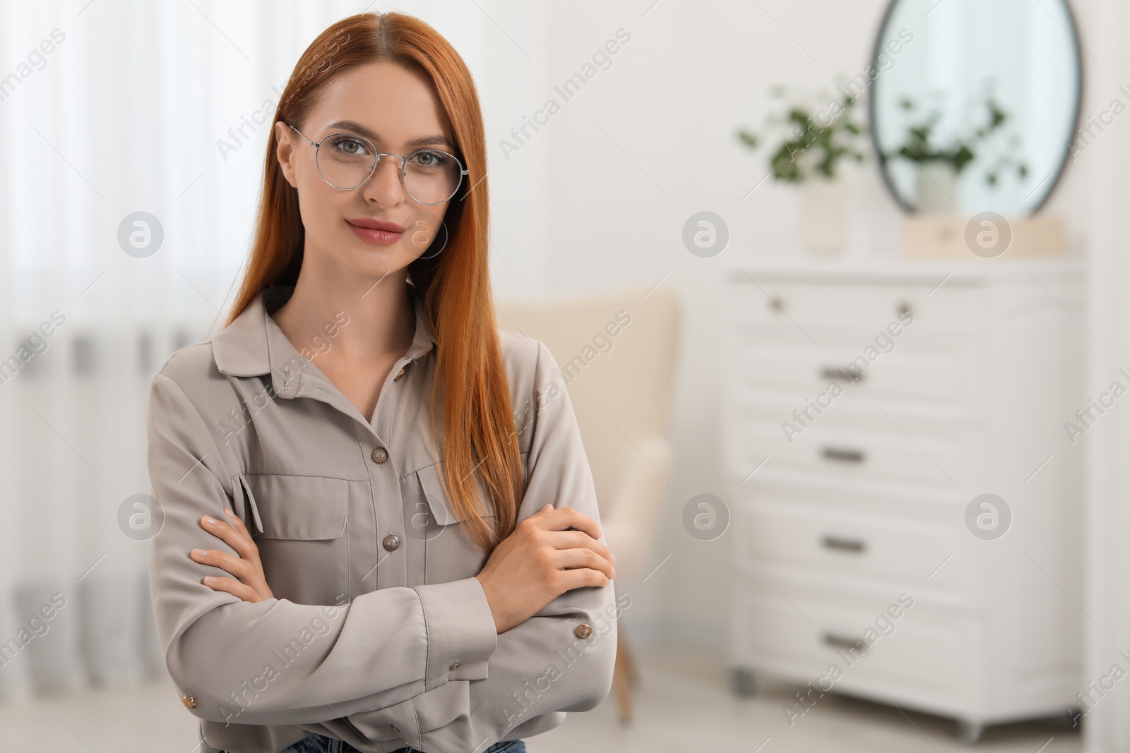 Photo of Portrait of beautiful young woman with red hair at home. Attractive happy lady looking into camera. Space for text