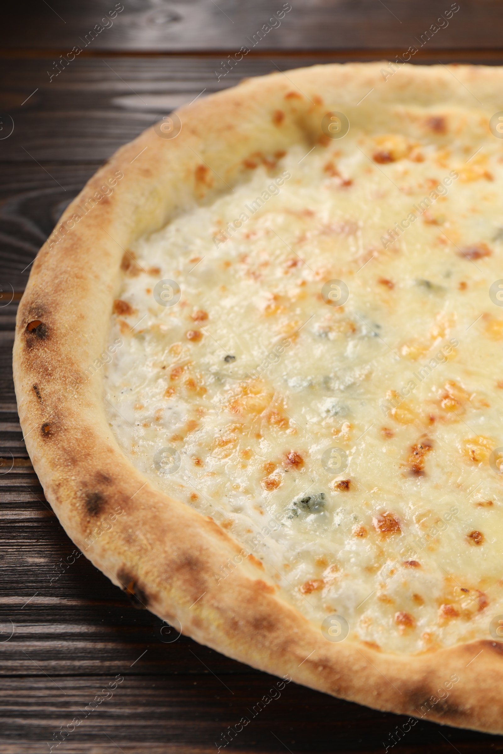 Photo of Delicious cheese pizza on wooden table, closeup