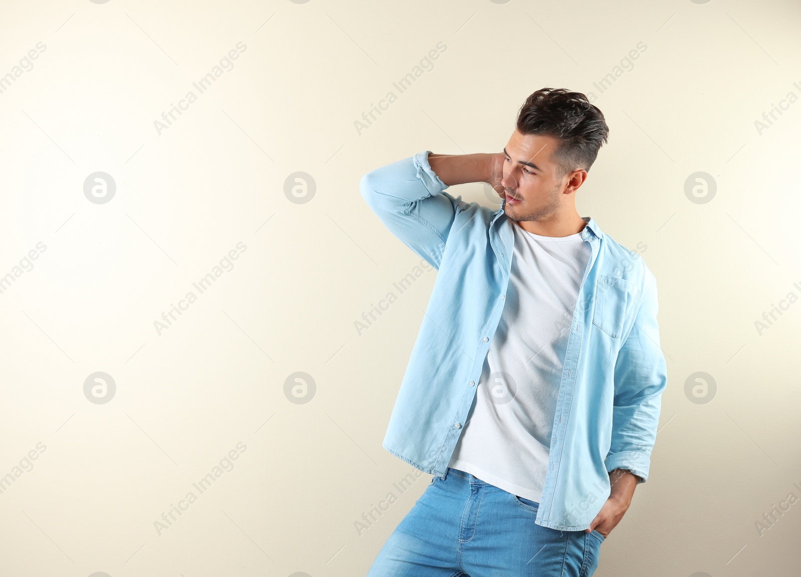 Photo of Young man in stylish jeans on color background with space for text