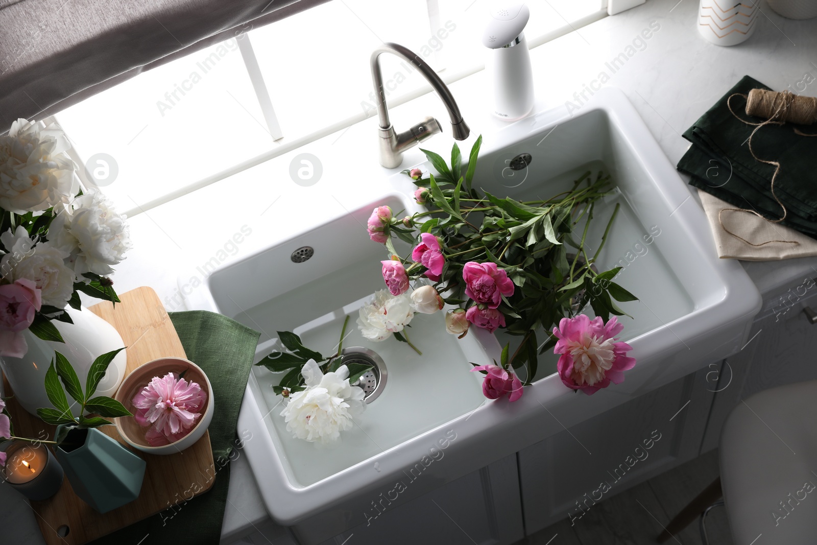 Photo of Beautiful kitchen counter design with fresh peonies, above view