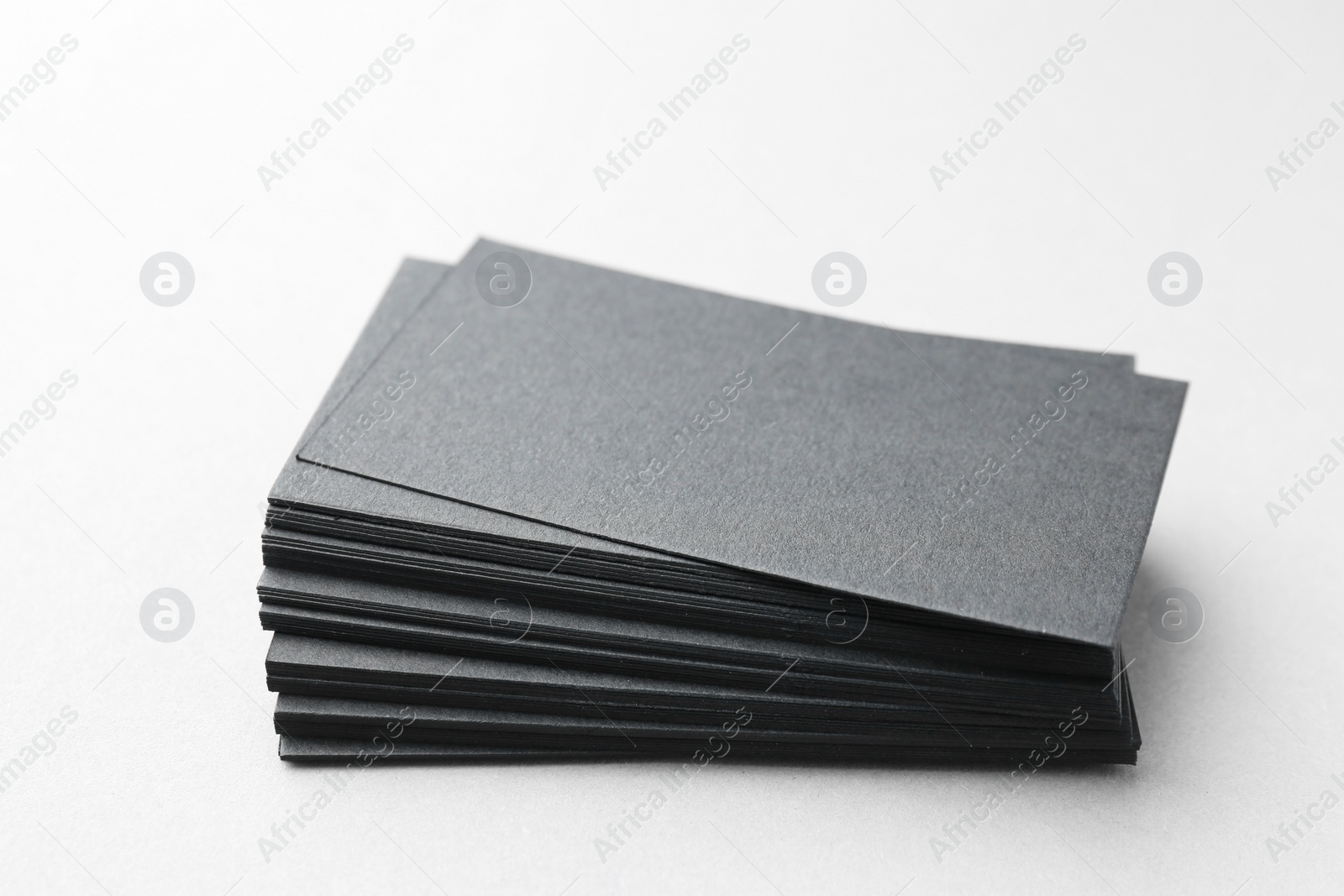 Photo of Blank black business cards on white table, closeup. Mockup for design