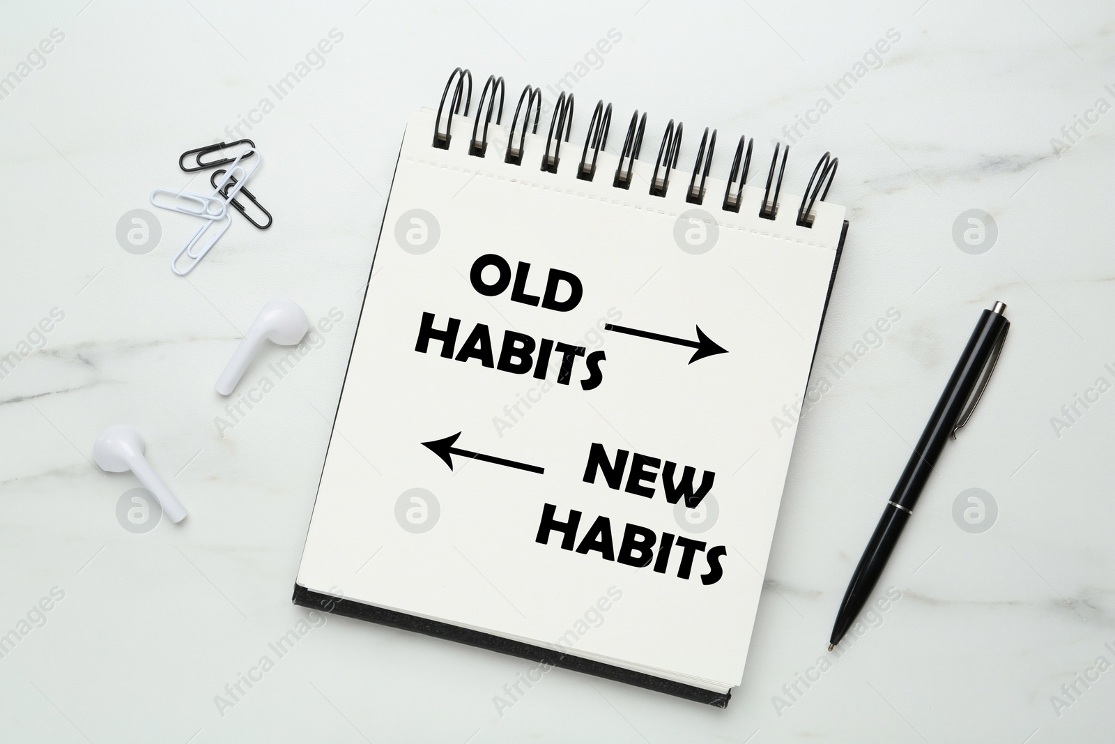 Image of Notebook with two opposite directions to Old and New Habits on white marble background, flat lay