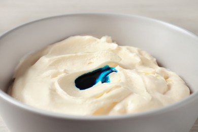 Photo of Bowl of cream with blue food coloring, closeup