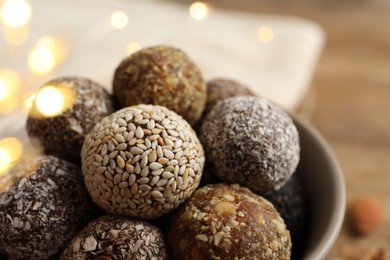 Photo of Different delicious vegan candy balls in bowl, closeup