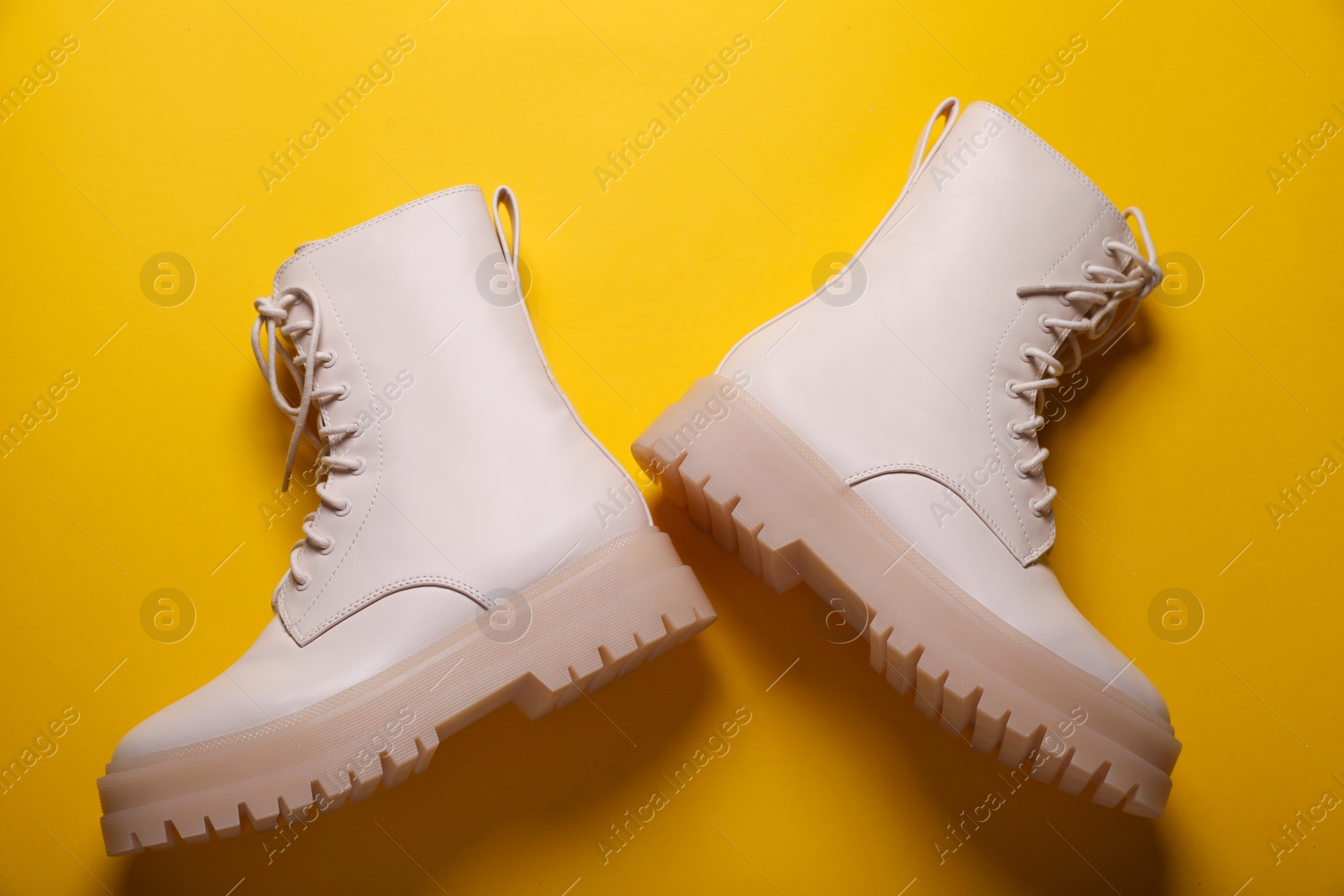 Photo of Pair of stylish leather shoes on yellow background, flat lay