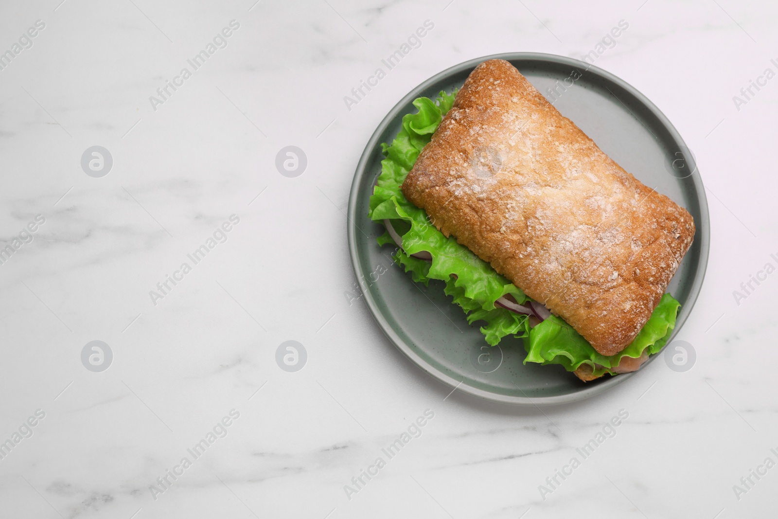 Photo of Delicious sandwich with fresh vegetables and salmon on white marble table, top view. Space for text