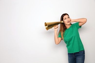 Photo of Young woman with megaphone on white background. Space for text
