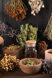 Many different dry herbs and flowers on wooden table