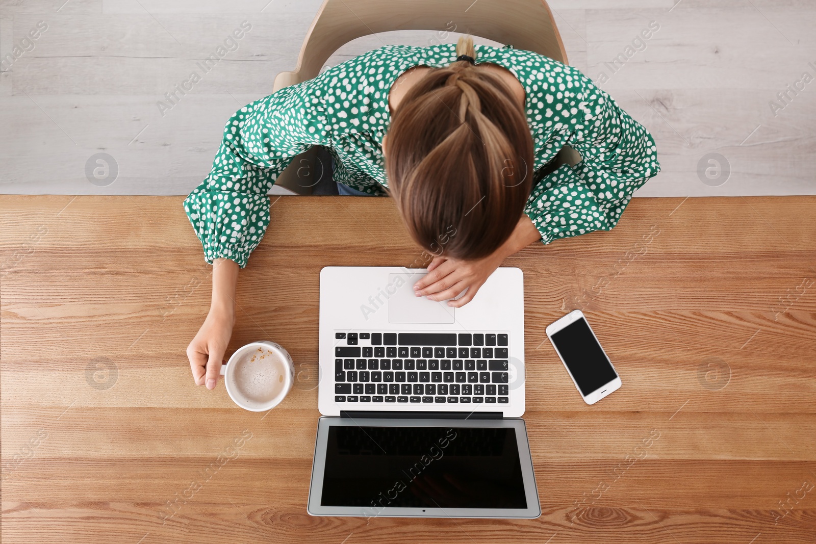 Photo of Woman working with laptop at table indoors, top view