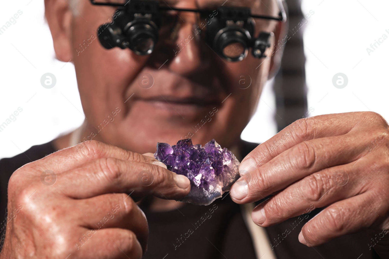 Photo of Professional jeweler working with beautiful amethyst, closeup