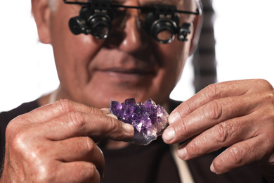 Photo of Professional jeweler working with beautiful amethyst, closeup