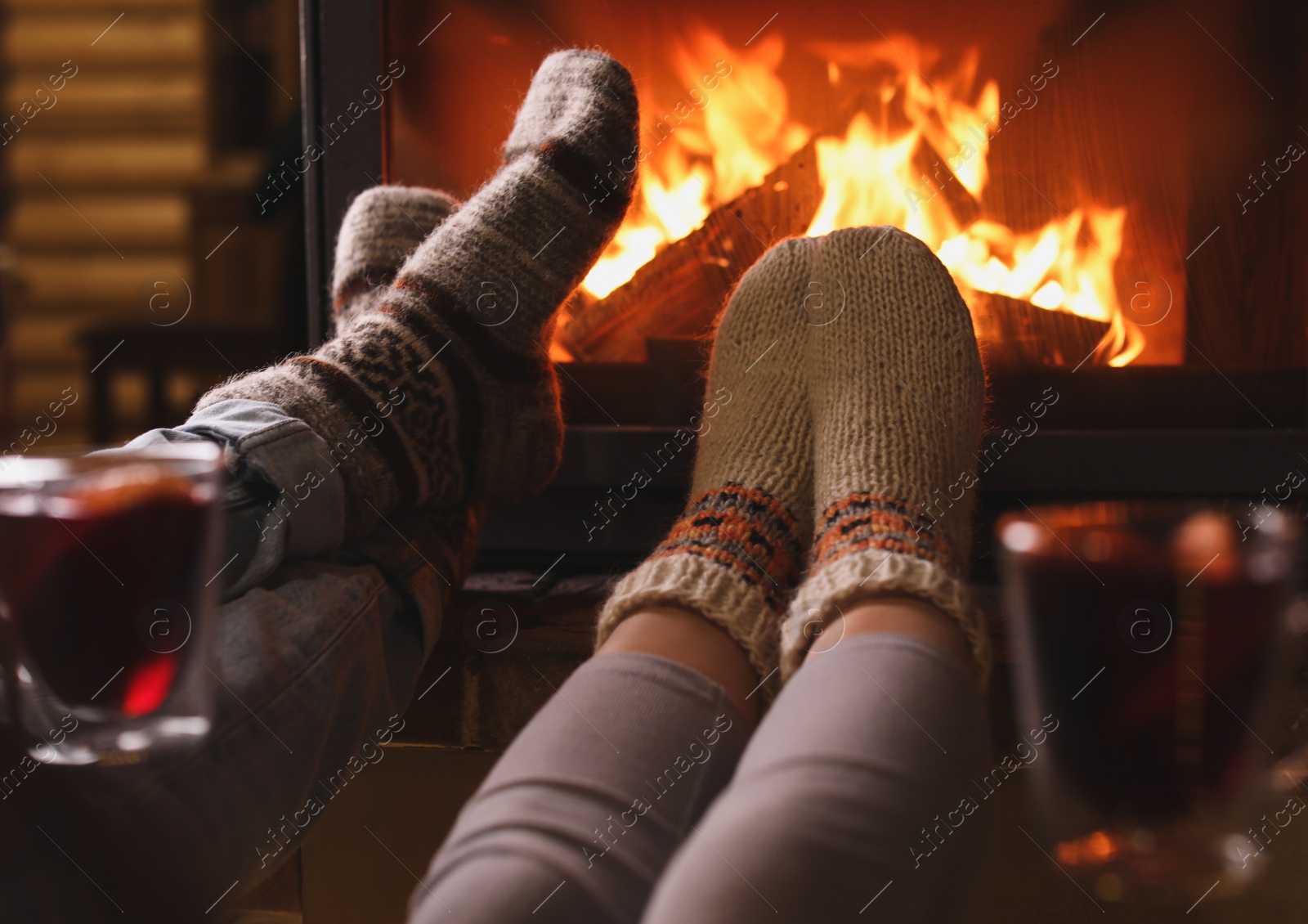 Photo of Couple resting near fireplace indoors, closeup. Winter vacation