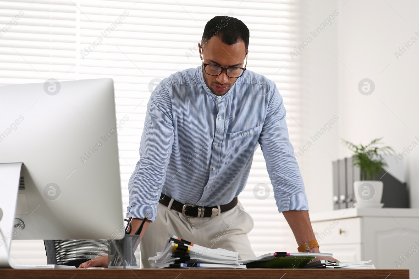 Photo of Businessman working with documents at wooden table in office