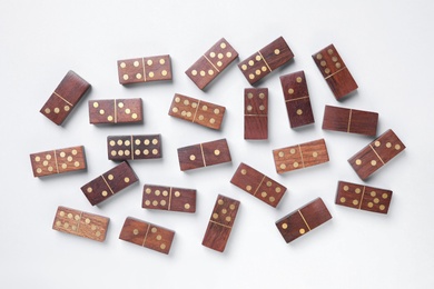 Wooden domino tiles on white background, flat lay