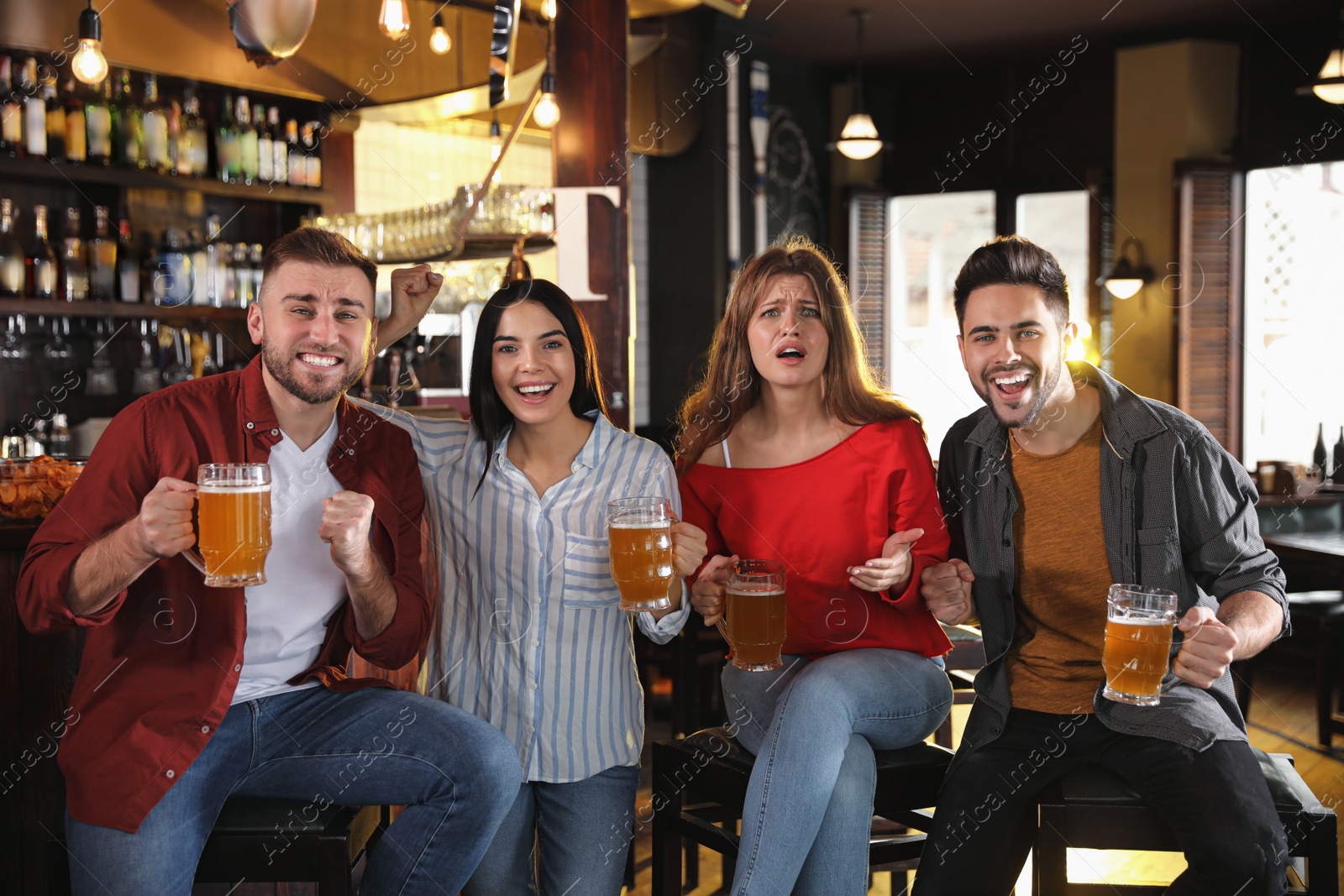 Photo of Group of friends watching football in sport bar