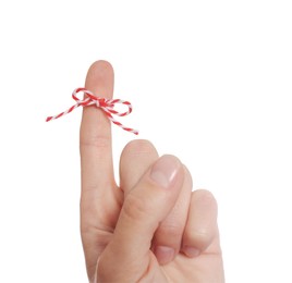 Woman showing index finger with tied bow as reminder on white background, closeup