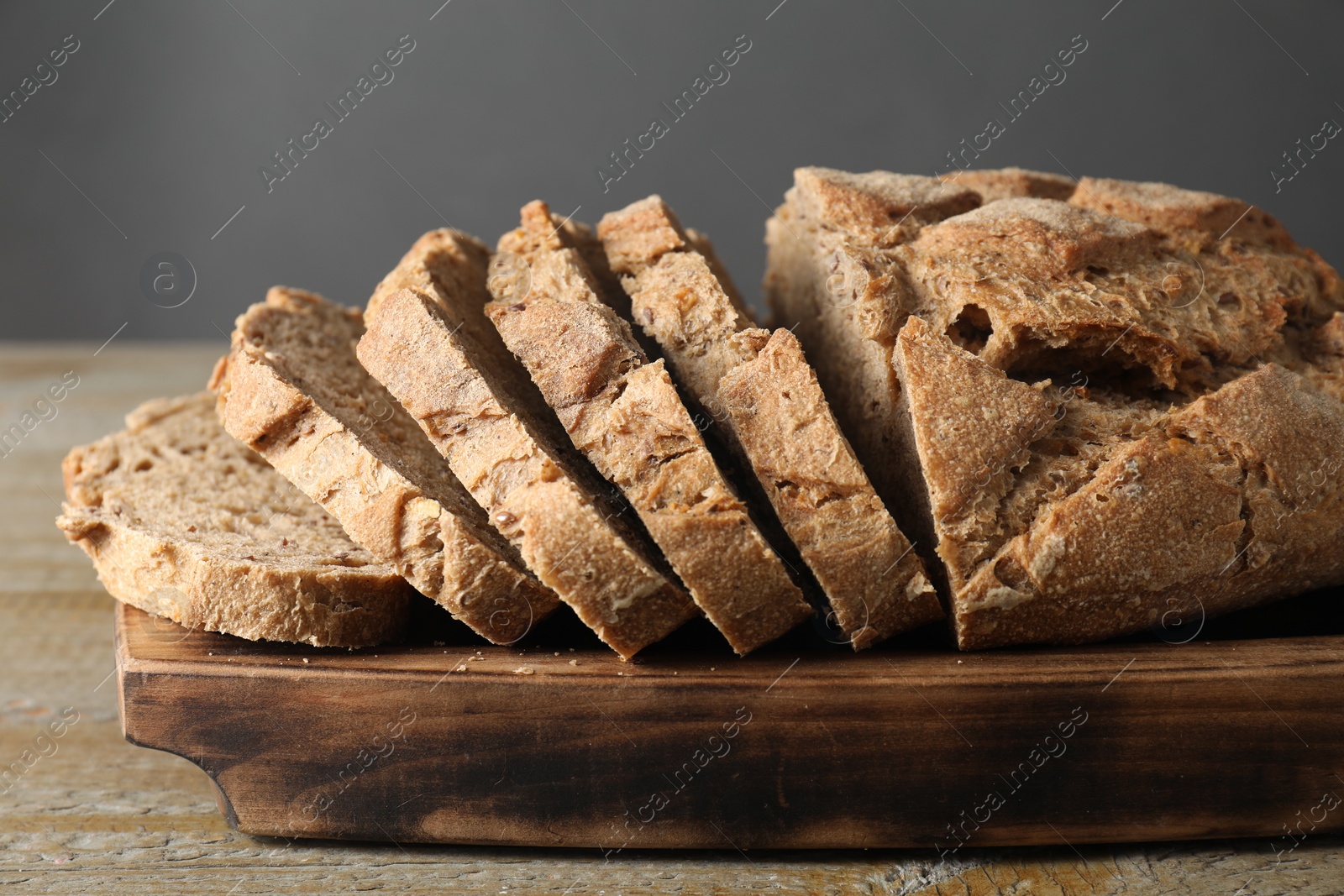 Photo of Freshly baked cut sourdough bread on wooden table, closeup