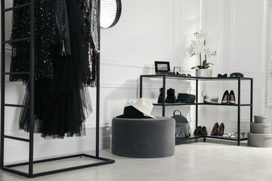 Photo of Stylish dressing room interior with trendy clothes, shoes and accessories