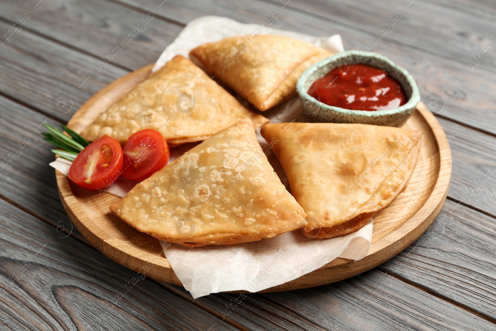 Photo of Fresh delicious crispy samosas served on wooden table, closeup