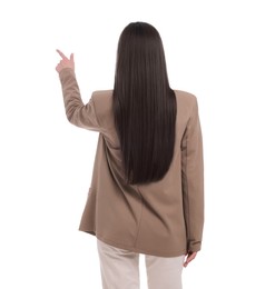 Businesswoman in suit pointing at something on white background, back view