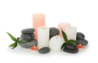 Beautiful spa composition with candles and stones on white background