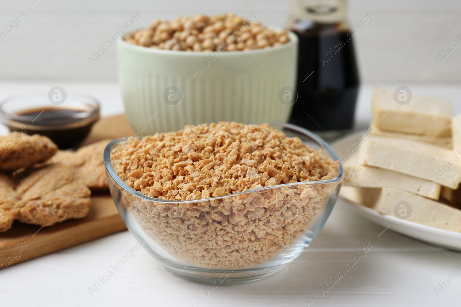 Photo of Dried soy meat and other products on white wooden table, closeup