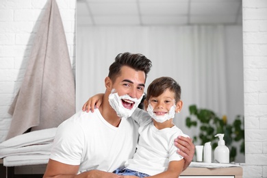 Father and son having fun while shaving in bathroom