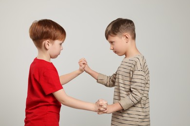 Photo of Two boys fighting on light grey background. Children's bullying