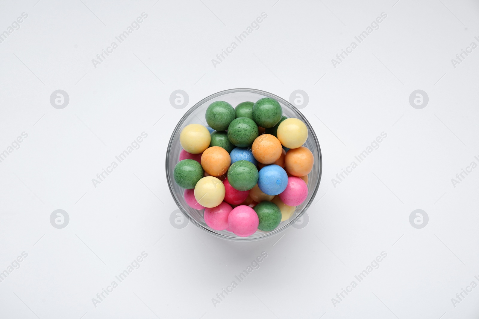 Photo of Bowl with many bright gumballs on white background, top view