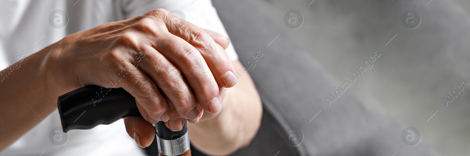 Image of Elderly woman with walking cane indoors, closeup. Banner design