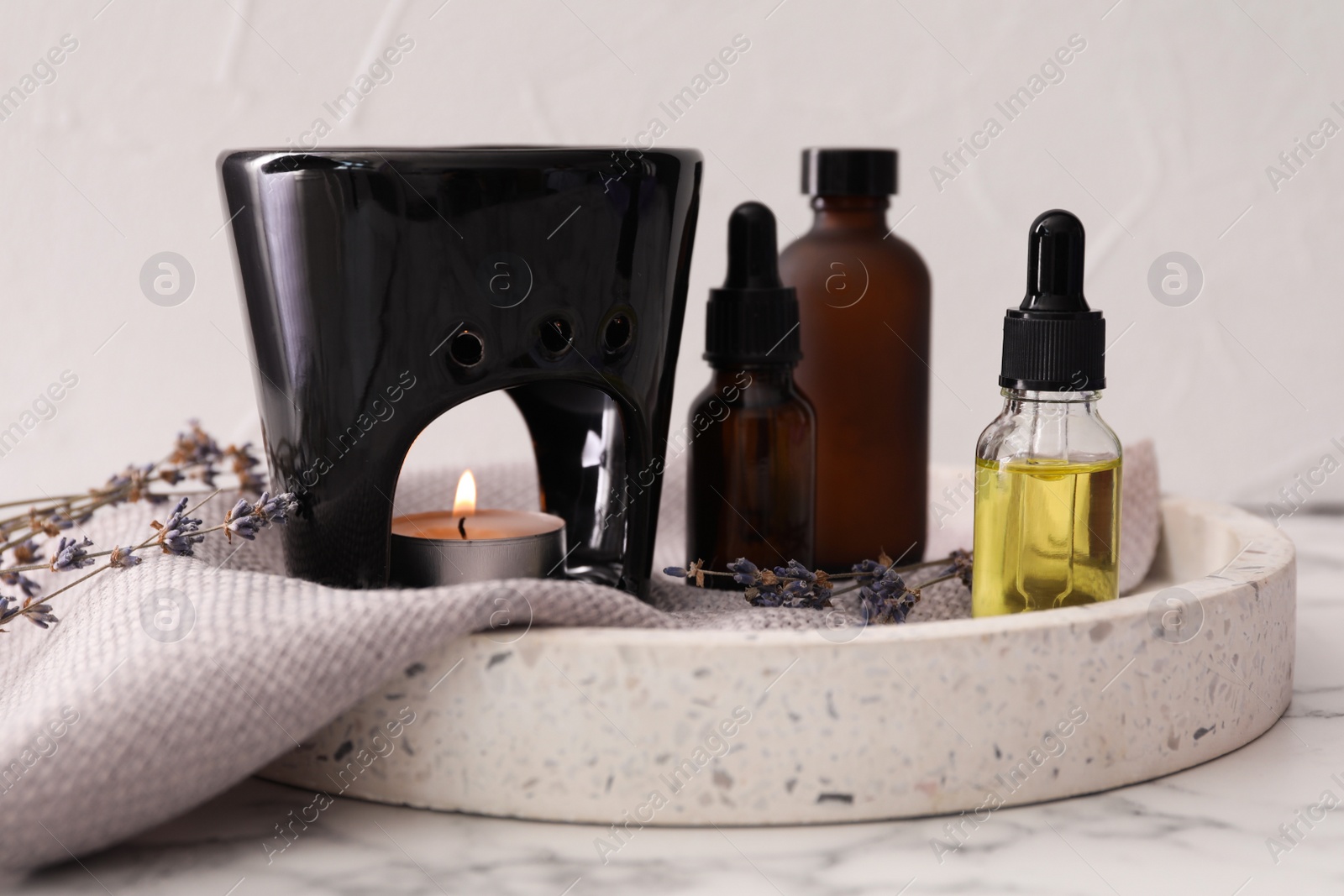 Photo of Composition with aroma lamp and lavender essential oil on white marble table