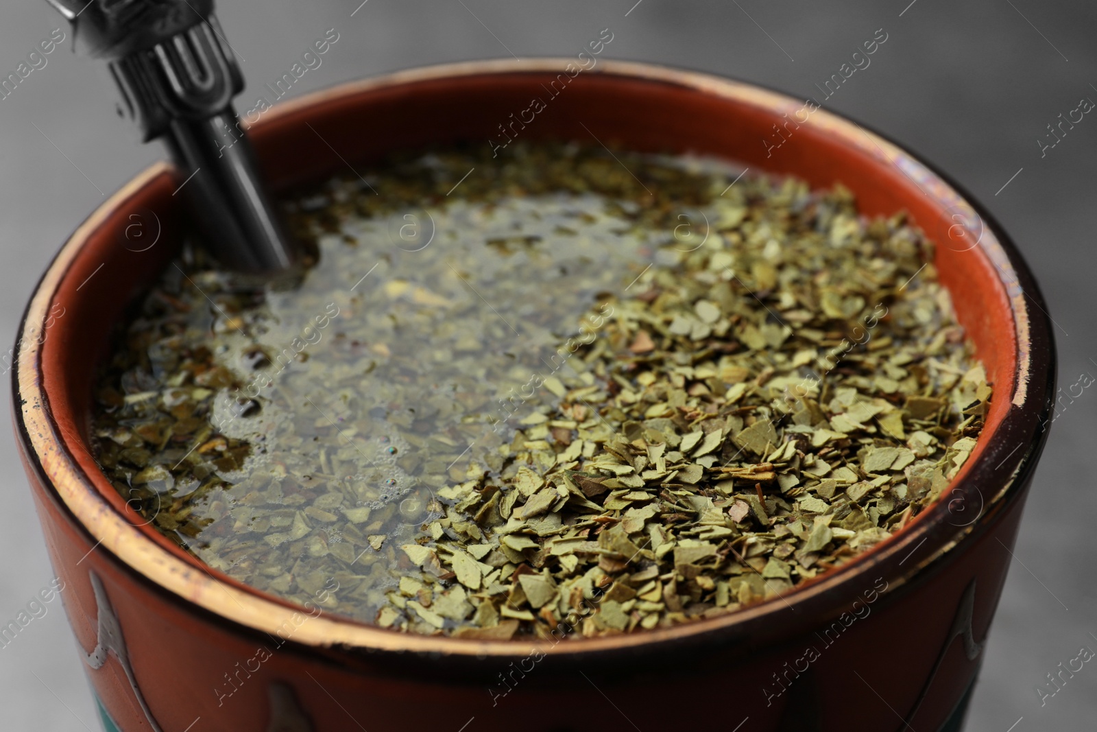Photo of Guampa with bombilla and mate tea on table, closeup