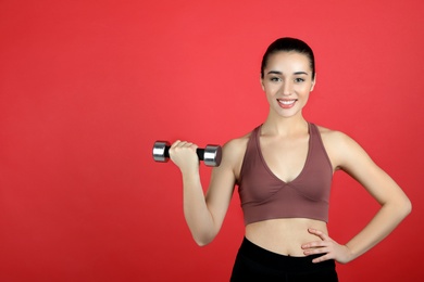 Photo of Woman with dumbbell as girl power symbol on red background, space for text. 8 March concept